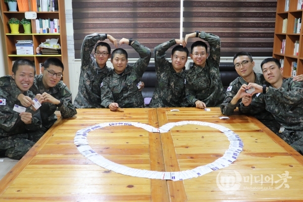 육군 11탄약창 장병들이 한국소아암재단과 백혈병어린이재단에 기부할 헌혈증 1000장으로 하트모양을 만들어 기념사진을 찍고 있다. 육군군수사령부 제공